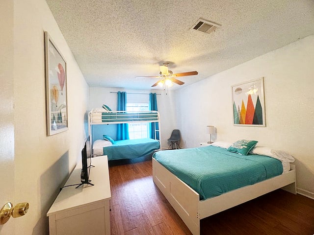 bedroom with queen bed and twin over twin bunk bed and 32" smart tv and blackout curtains
