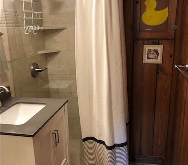 The bathroom is modern and stylish with shower, toilet and vanity