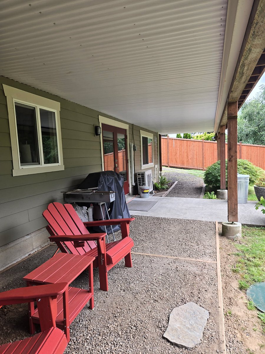 Covered outdoor sitting and barbecue area, offering a comfortable space to relax and enjoy the outdoors right by the unit.