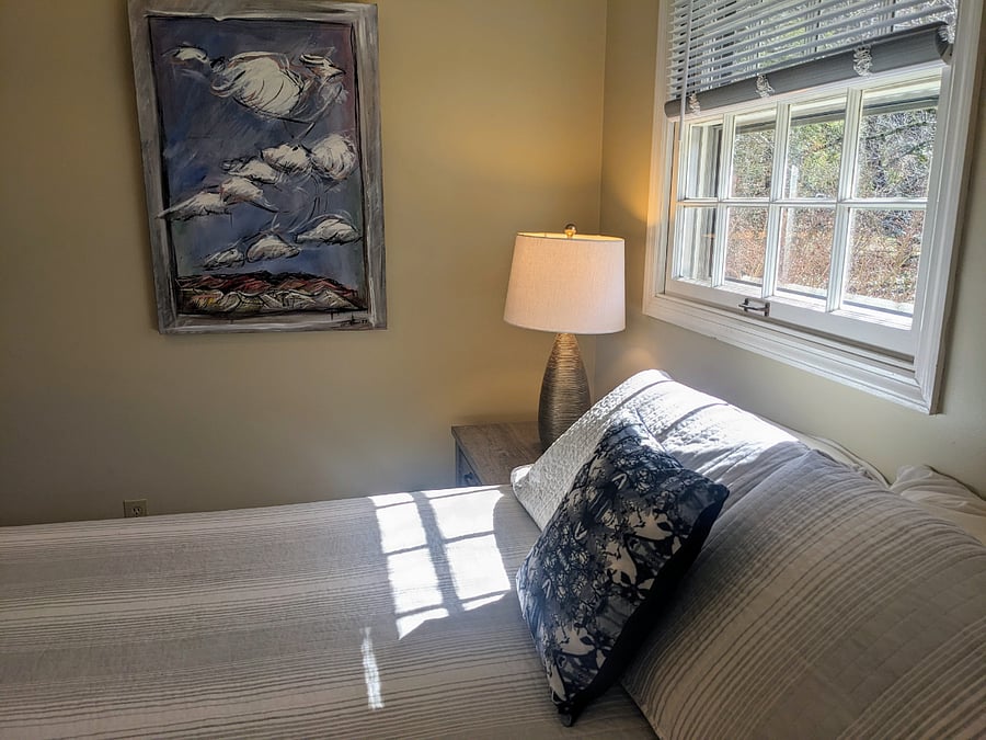 The second bedroom also has two windows for natural light and views of the landscaped property.