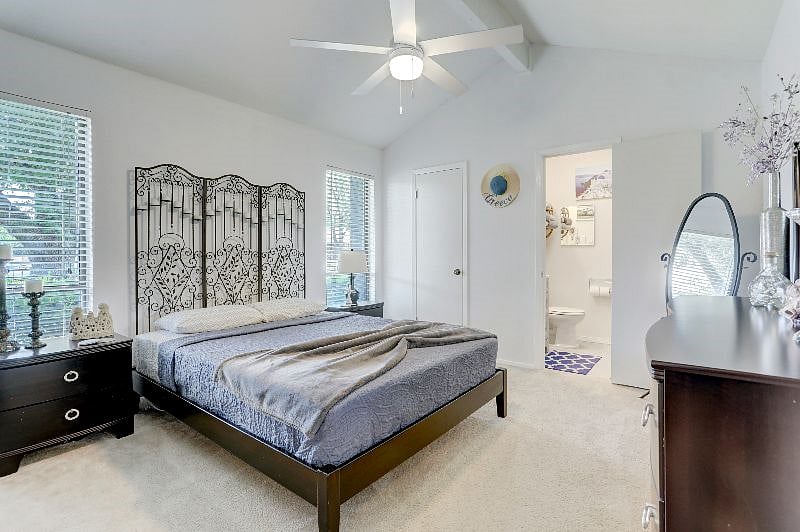 The master bath has a walk-in shower with large grey tiles and bluetooth speaker.