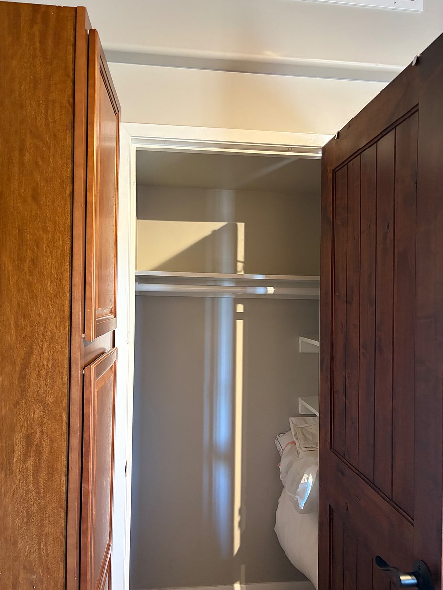 Closet space with shelving on the right hand side.