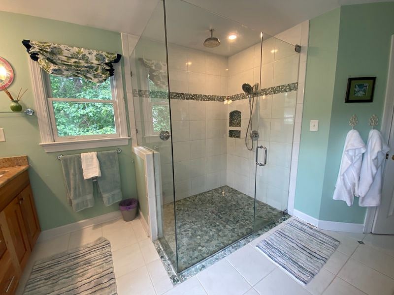 Master bath with dual sinks, granite counters, shower with 2 shower heads, shampoo/soap niches, & soaking tub.