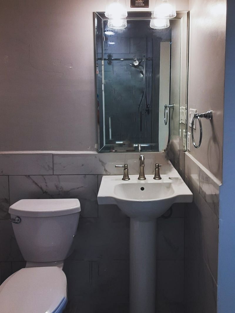 The bathroom is modern and stylish with shower, toilet and vanity