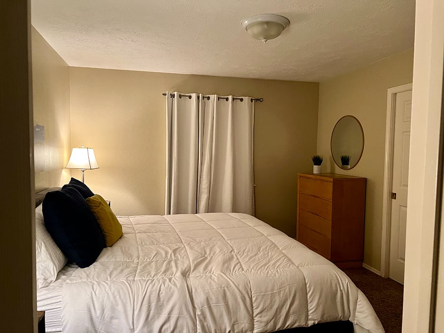 Master bedroom with a show and a tub.  King size bed and black out curtains.