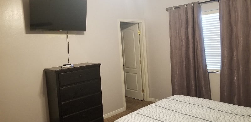 Master bedroom with large smart tv.