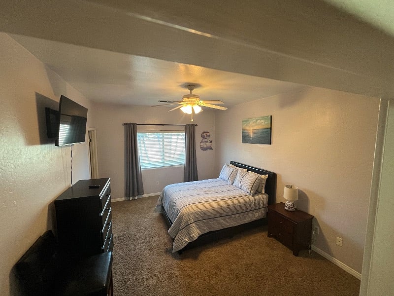 Master bedroom with private bath and large smart TV.