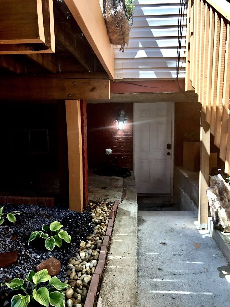 Private entrance under deck in backyard with access to ally street