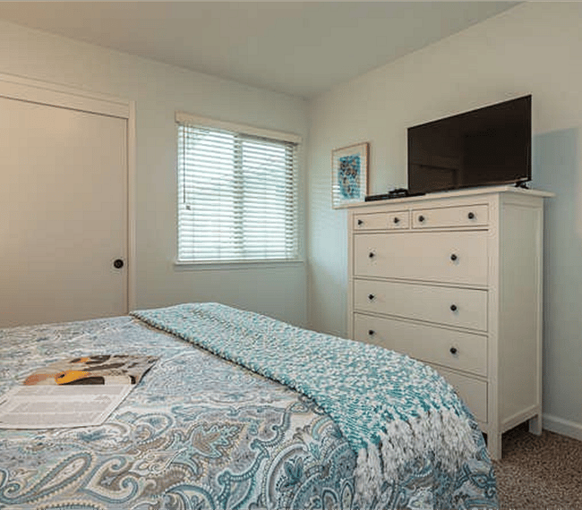 Upstairs - Bedroom One, with dresser, TV, Queen Bed and Closet with Iron.