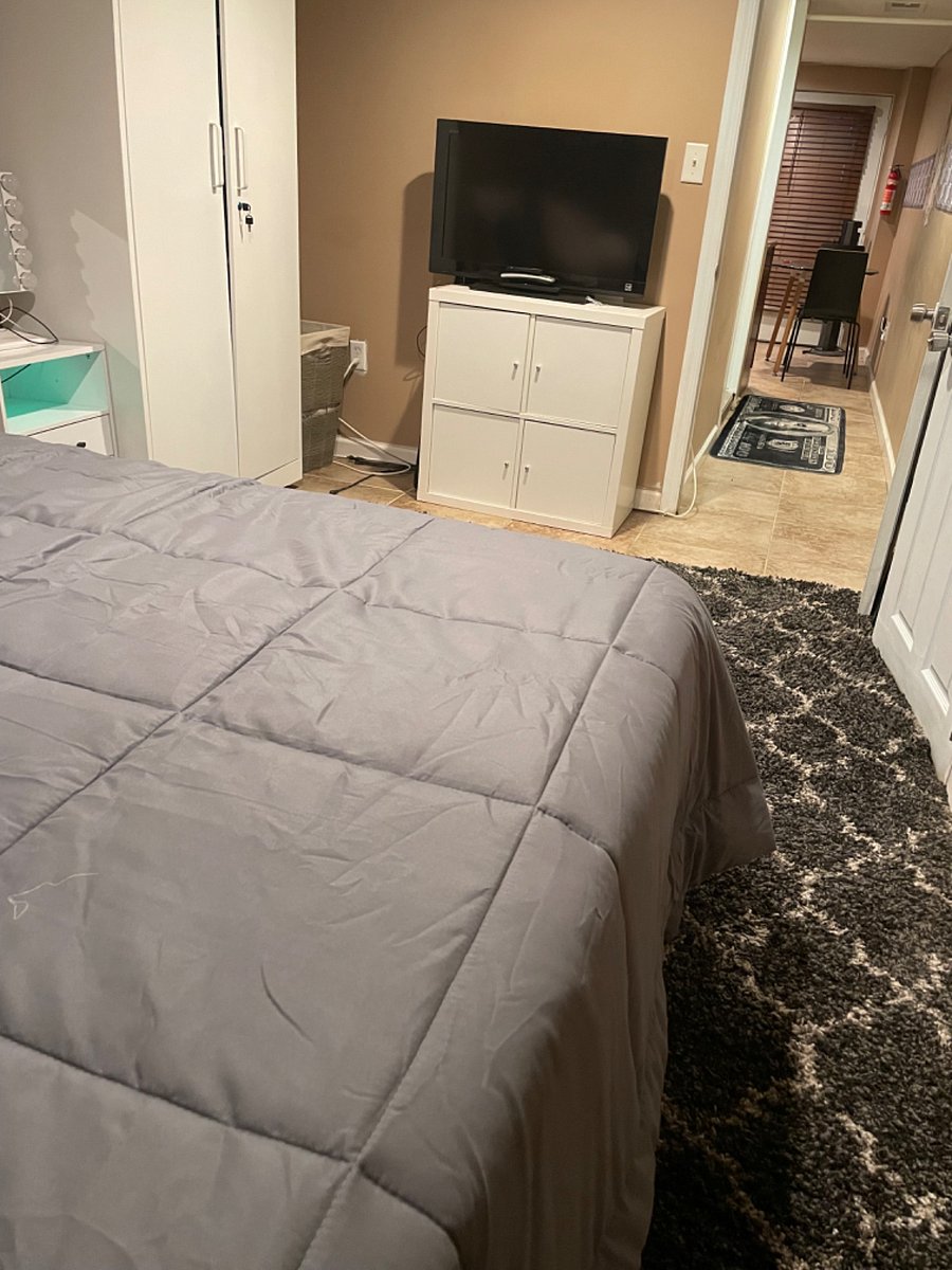 Bedroom with closet space and charging station, leading into hallway