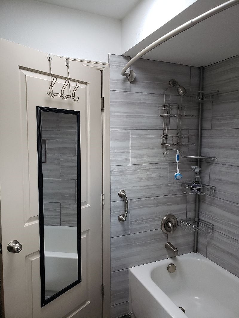 Another picture of your beautiful tile bathroom-tub walls, showing all the extra "goodies" you can have at your fingertips with the caddies provided...