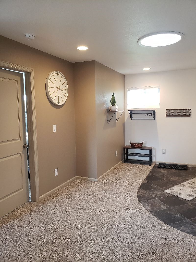 Looking from the hall towards your bedroom door on the left and also towards the front door. Key holder, shelves, shoe holders and there's that BIG clock again...
