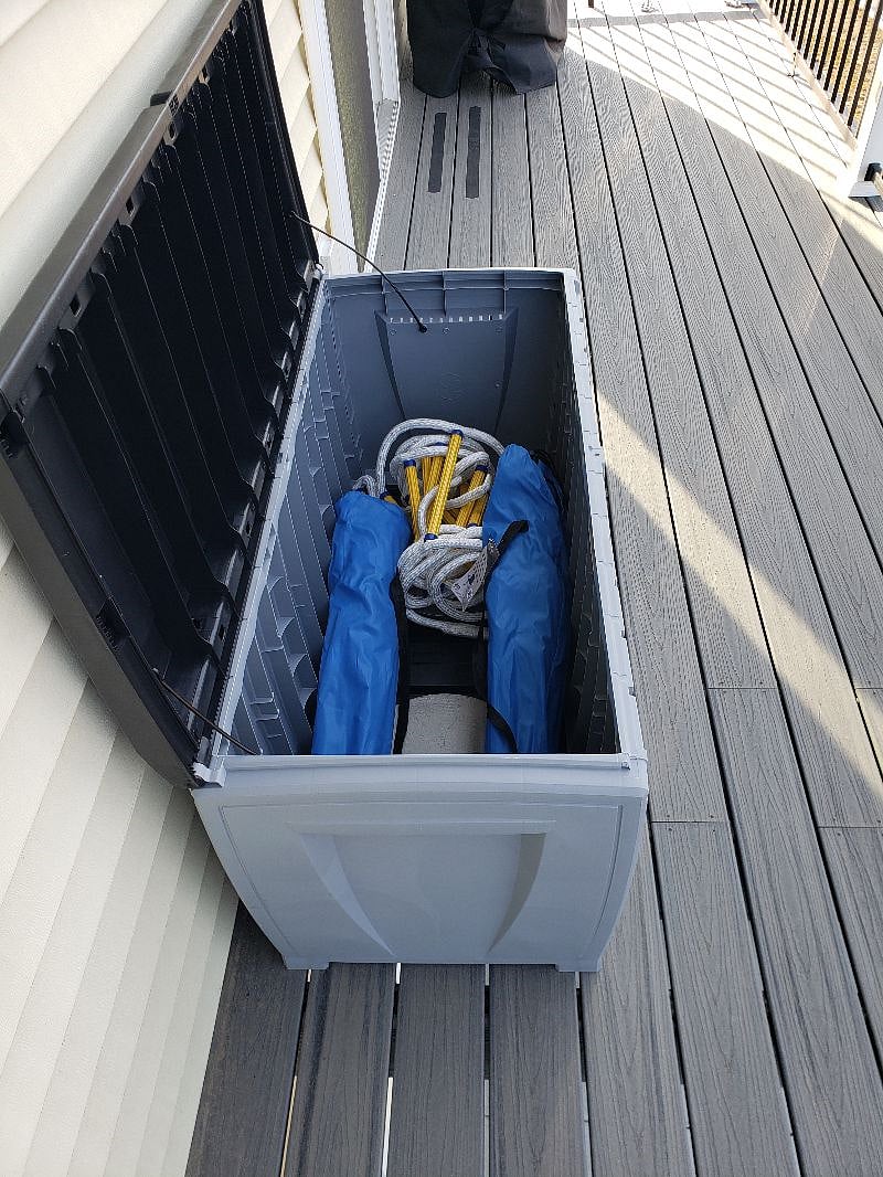 Large deck storage bin has fire escape ladder and several fold out chairs to relax in..