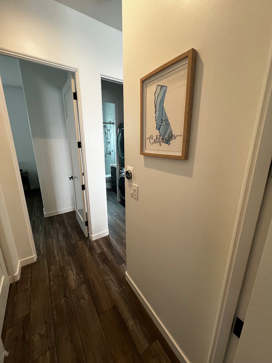 small hallway from master to 2nd bedroom. Hallway has closet for supplies