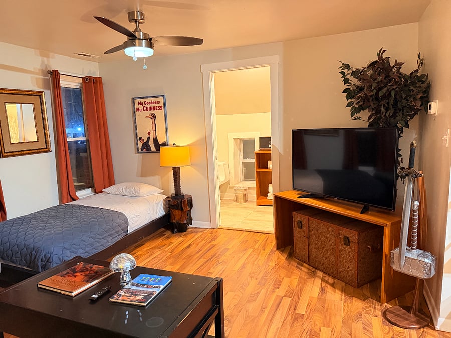 Relax in a cozy living room with comfortable seating, enjoy your favorite shows on the TV, and rest comfortably on the twin bed.