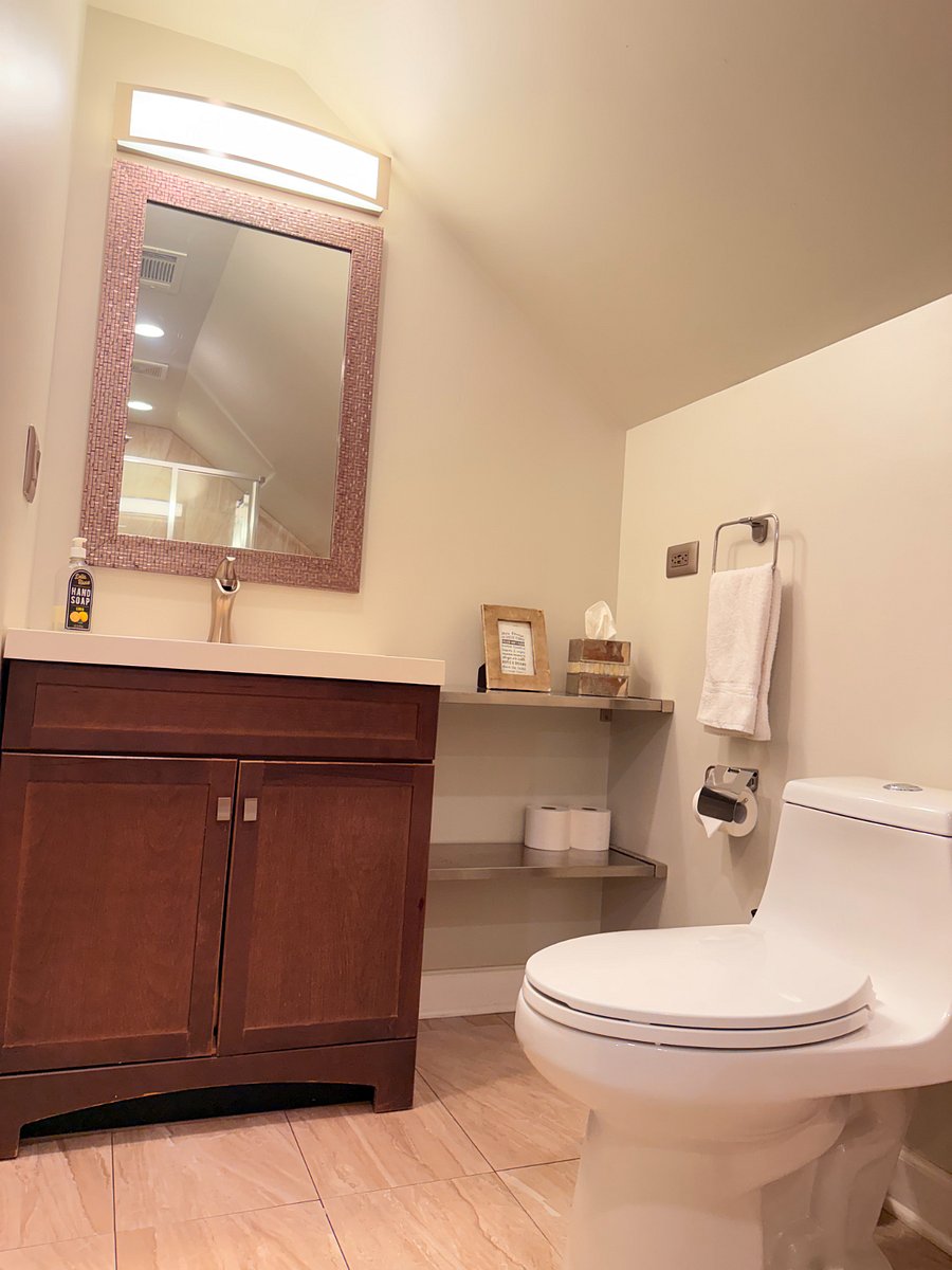 Well-equipped bathroom with a modern sink, convenient toilet, and a large mirror for your daily routine.