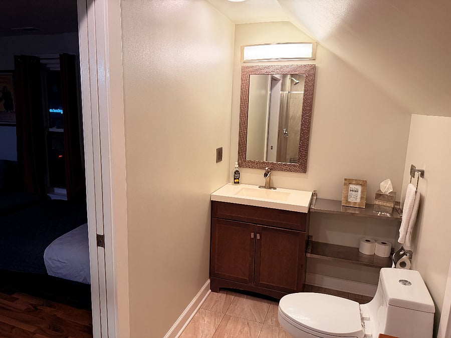 Well-equipped bathroom with a modern sink, convenient toilet, and a large mirror for your daily routine.