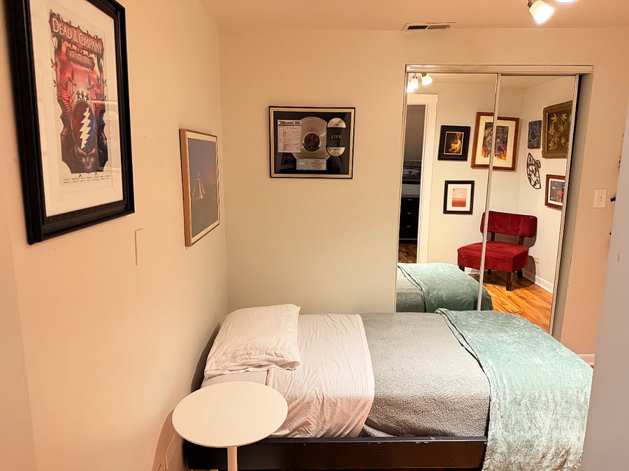 A clean, comfortable bed with fresh linens and a cozy little nook with a chair and soft accents. Simple touches that make the space feel warm and inviting.