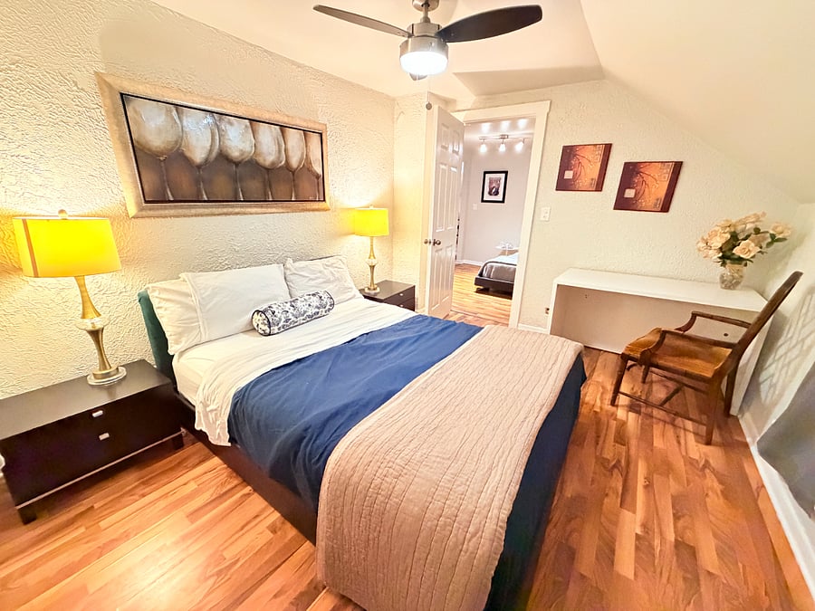 Relax in the inviting bed room featuring a queen bed and a dedicated workspace to meet all your work needs.