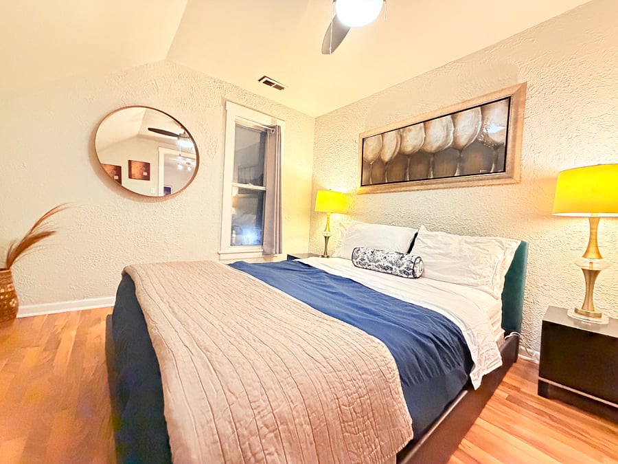 Relax in the inviting living room with a queen bed accented by two bedside lamps.