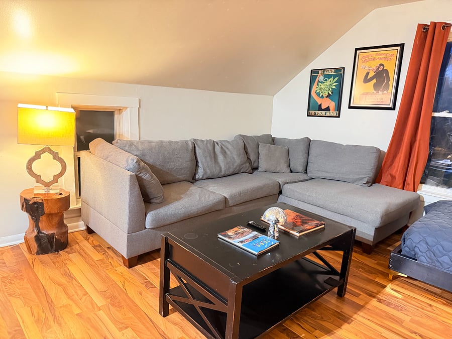 Relax in a cozy living room with comfortable seating, enjoy your favorite shows on the TV, and rest comfortably on the twin bed.