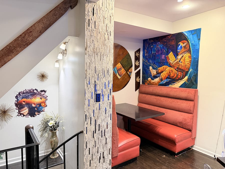 Dining nook with comfortable booth seating, contemporary accents, and bold artwork. An inviting spot for meals, coffee, or conversation.
