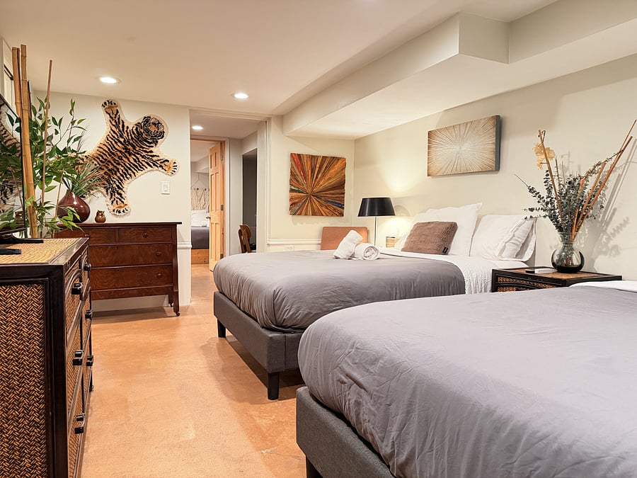 Sleep comfortably with two queen beds, fresh linens, and a flat-screen TV. A serene forest mural and a spacious dresser add a calming touch and plenty of storage for a relaxed, settled stay.
