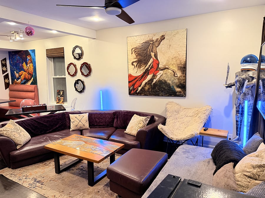 Unwind in a cozy living space with vibrant decor, Smart TV, a comfortable sectional and plenty of natural light. Ideal for relaxing or entertaining