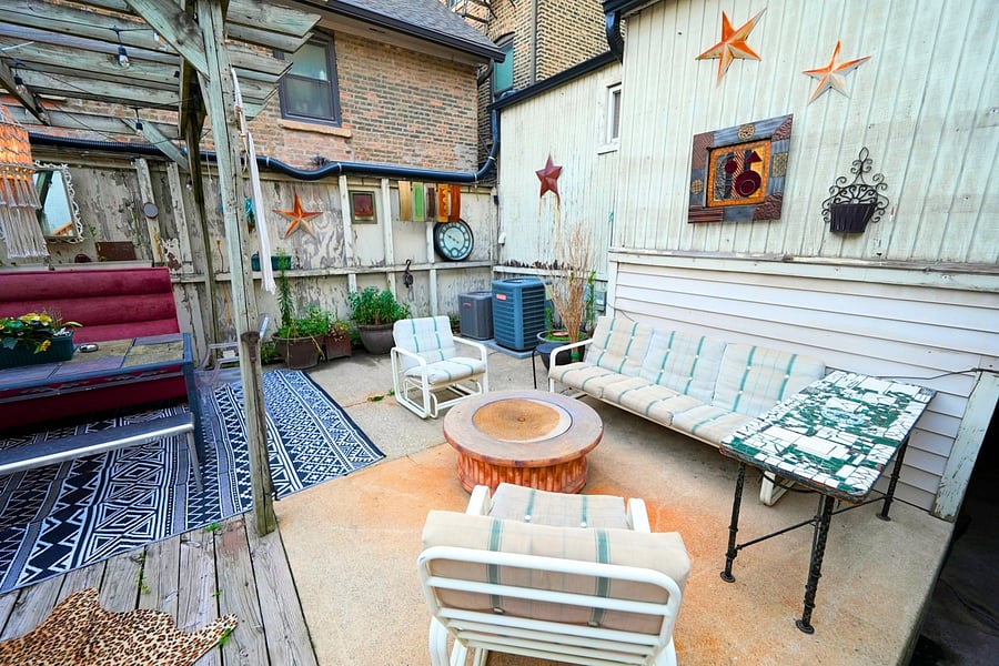 Shared backyard patio with lots of seating, perfect for relaxing and enjoying the serene outdoor atmosphere.