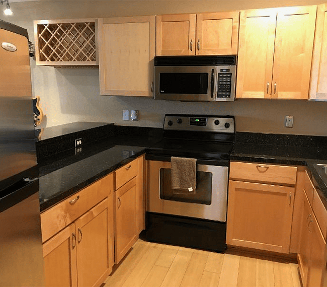 One-piece honed granite counter top kitchen with Stainless appliances.