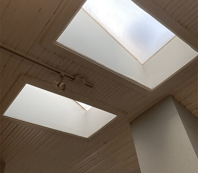 Two small skylights in a shiplap ceiling provide soft lighting.