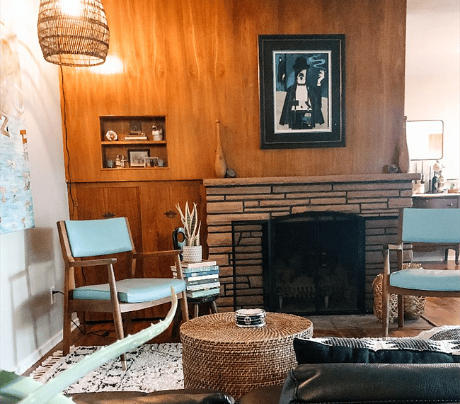Fully functioning fireplace opposite the couch in Living Room. A ROKU TV has replaced this print above the fireplace. Dining Room can be seen to the right.