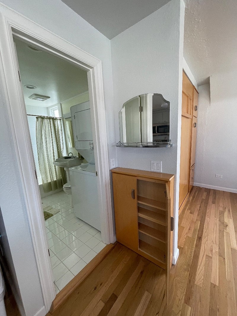 Extra vanity outside bathroom, includes storage shelves.