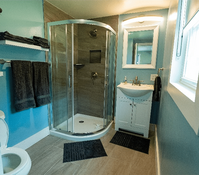 Full bathroom with walk-in shower, vanity sink and mirror