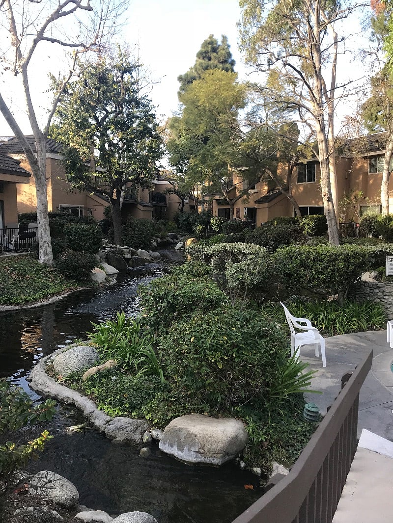 Nature preserve path and running streams in gated complex with benches