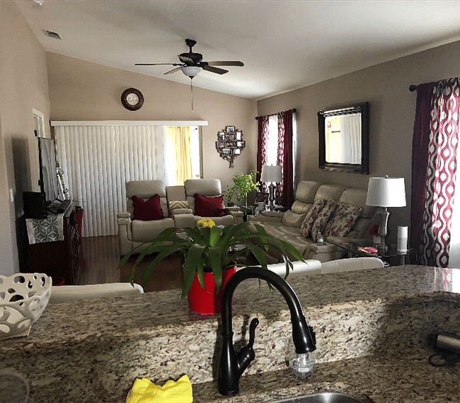 In kitchen looking at Living room with a leather couch, and loveseat. Both have 2 recliners each.