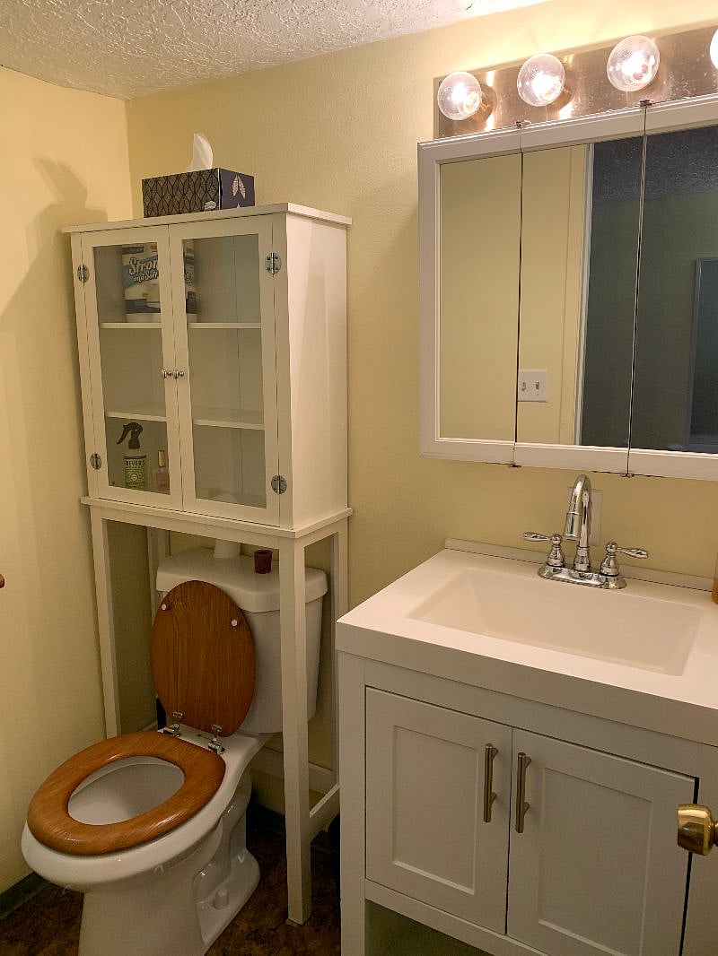Bathroom has a tub/shower as well as plenty of storage space.