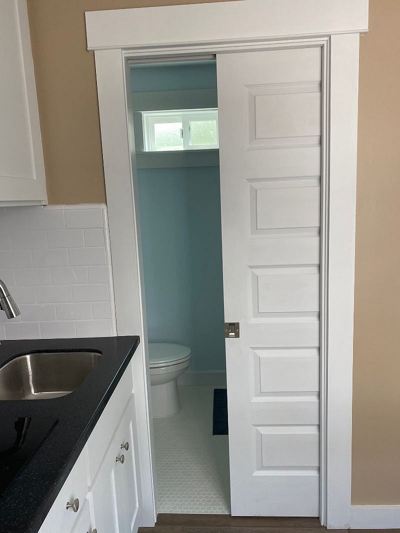 Pocket door leading into bathroom off of kitchen