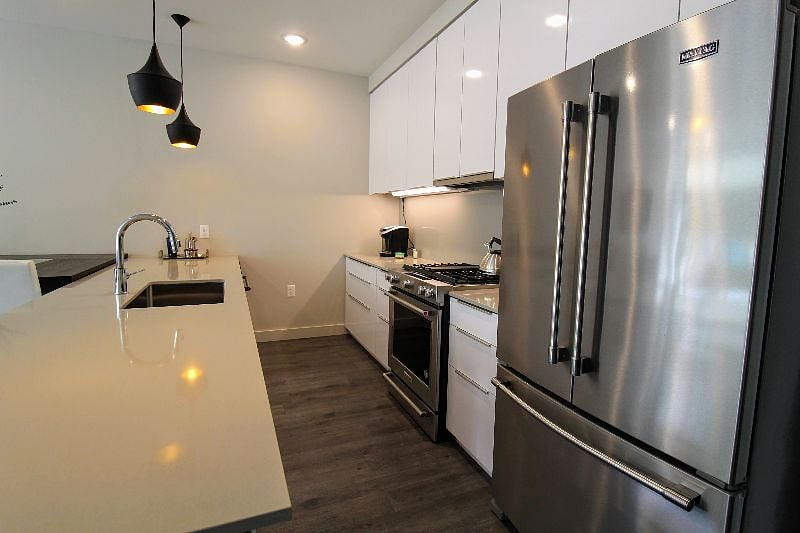 Full kitchen with stainless steel appliances and gas stove.