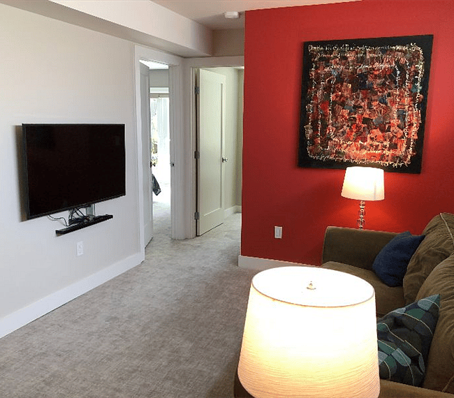 Light filled den showing flatscreen tv and looking towards bedroom 1 (door on the left) bedroom 2 (door on the right)