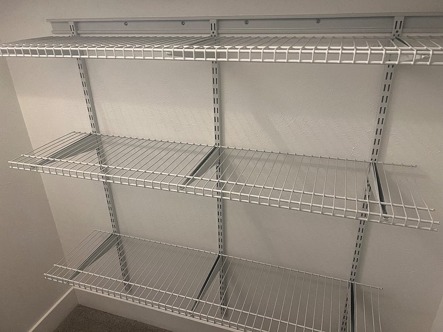 Walk-in closet with closet maid racks for keeping clothes.