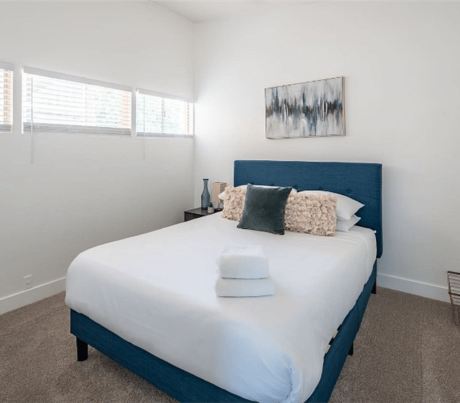 Queen size bed in the guest bedroom. It has a standard closet for keeping clothes and accessories.