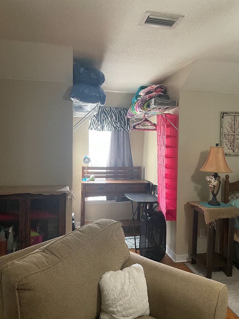 Desk area with closet and racks and extra linens. Also Tray table and chairs.