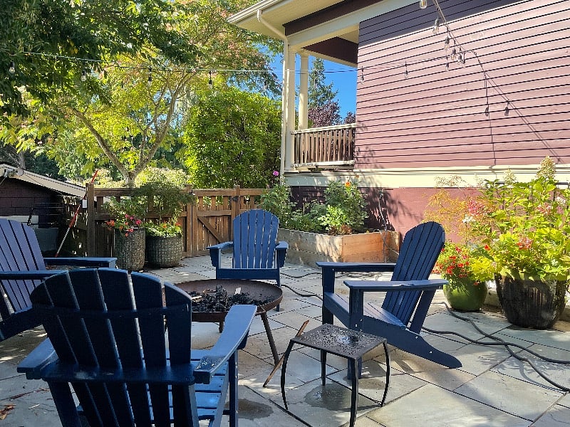 Outdoor patio with fire pit, raised urban bed with option for planting own vegetables or flowers.