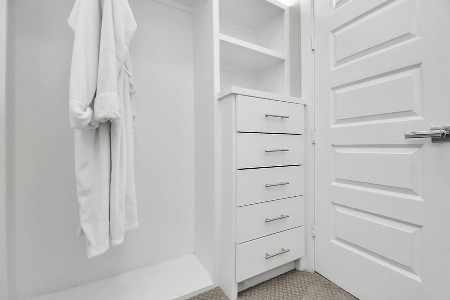 Spacious walk in closet in the master bedroom with custom shelves and built in drawers.