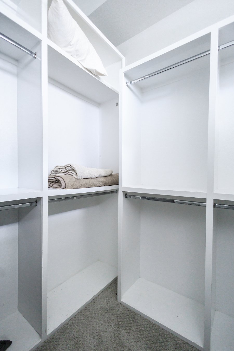 Spacious walk in closet in the master bedroom with custom shelves and built in drawers.