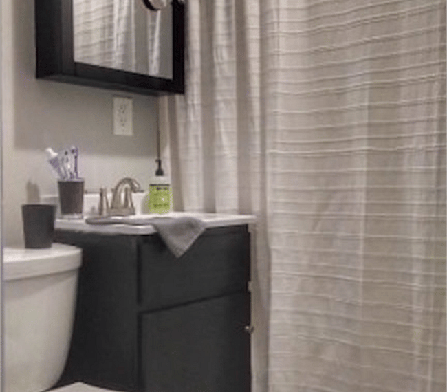 The bathroom is small but with enough storage and a full tub.