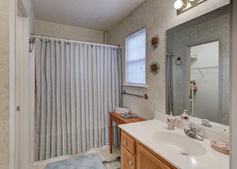 Master bathroom has an attached walk in closet complete with hangers, towels, and extra sheets and blankets; shower/tub combo