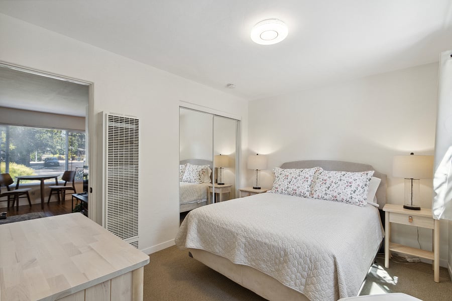 Bedroom with mirrored closet doors and dresser