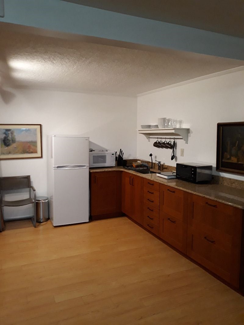 Fully outfitted kitchen with refrigerator, microwave, toaster oven, and induction cooktop (one of two) shown.